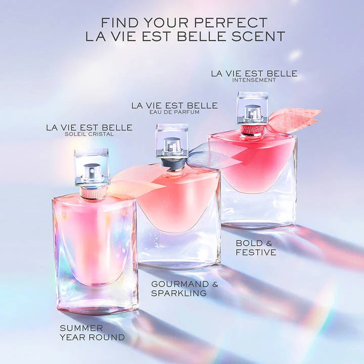 Three La Vie Est Belle perfume bottles on a gradient background