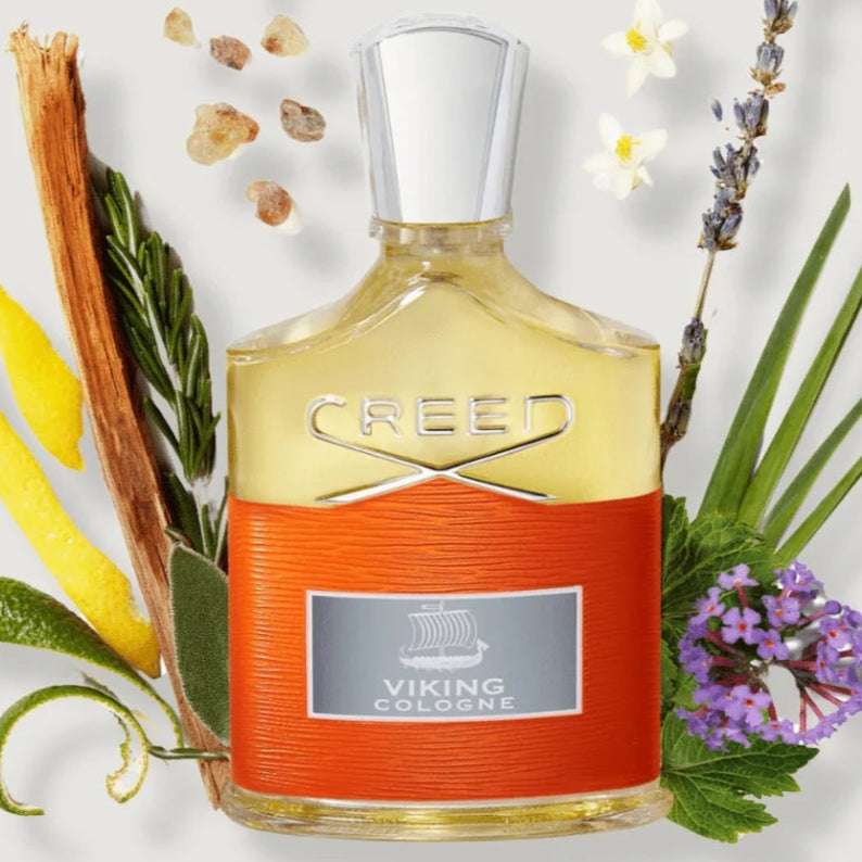 Creed perfume bottle with floral and botanical elements on a light background