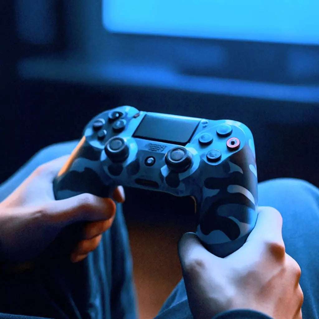 Person holding a gaming controller in front of a screen