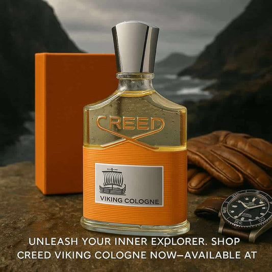 Creed Viking Cologne bottle with orange packaging, leather gloves, and watch on a mountainous background
