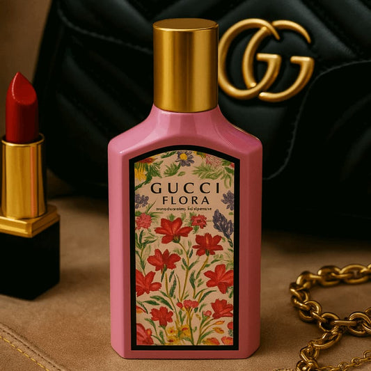 Gucci Flora perfume bottle with floral design, red lipstick, and Gucci bag in the background.