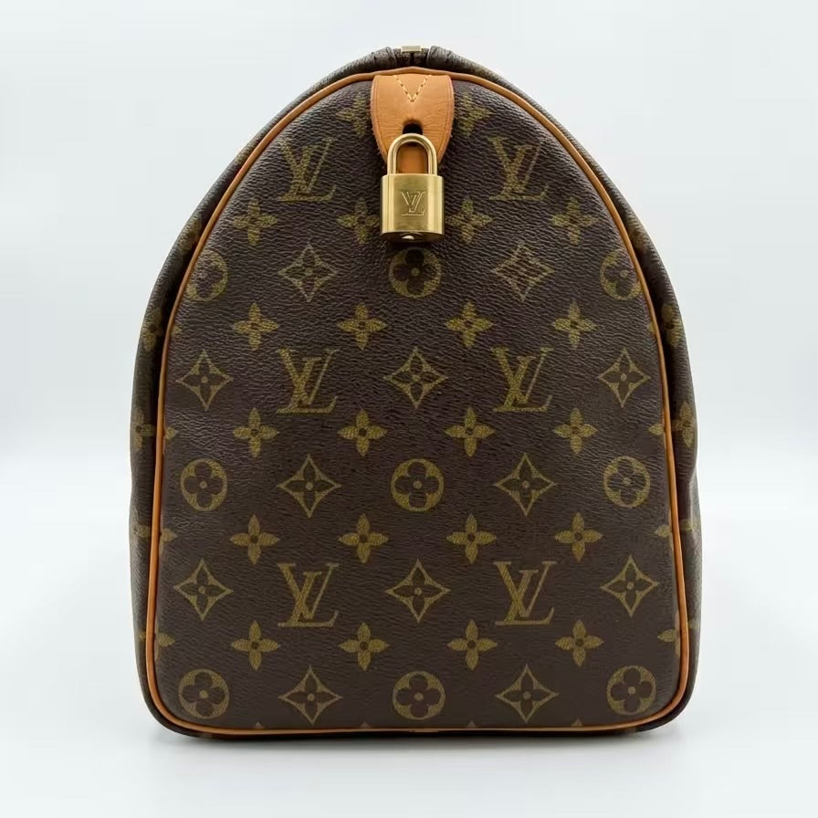 A symmetrical side profile view of a Louis Vuitton monogram canvas travel duffle bag, showcasing the iconic LV pattern alignment and a polished gold-tone padlock accentuating the leather trim.⁠