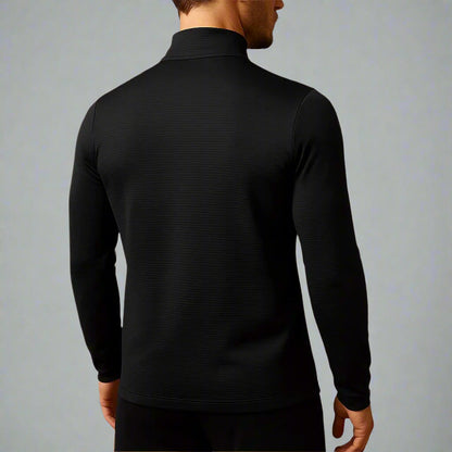 Person wearing a black long-sleeve shirt against a gray background