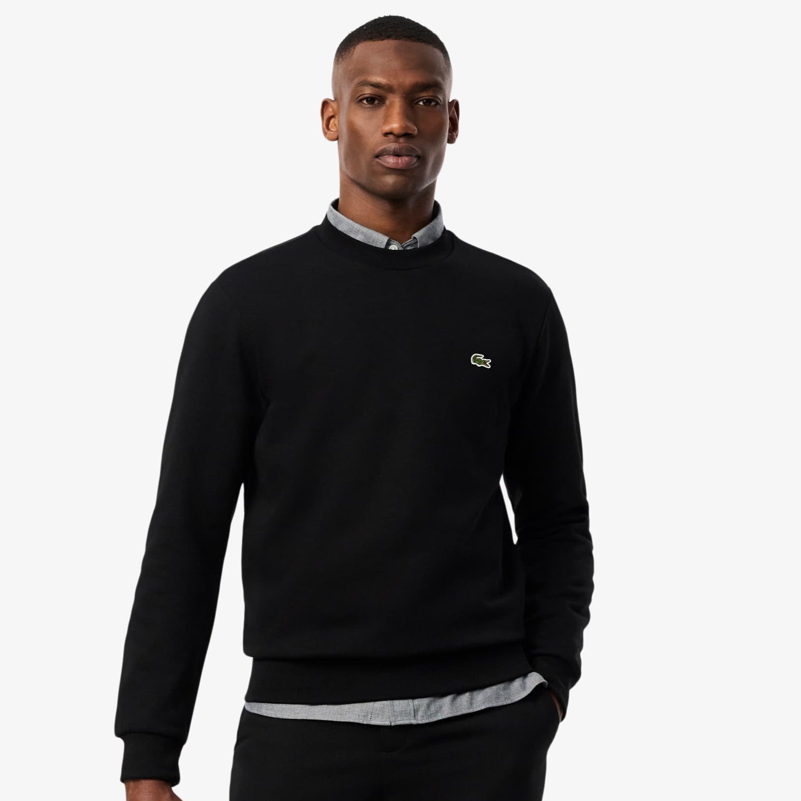 Man wearing a black sweatshirt with a brand logo on a white background