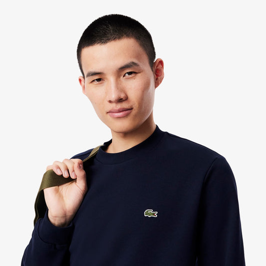 Man wearing a navy blue sweatshirt with a brand logo on a white background