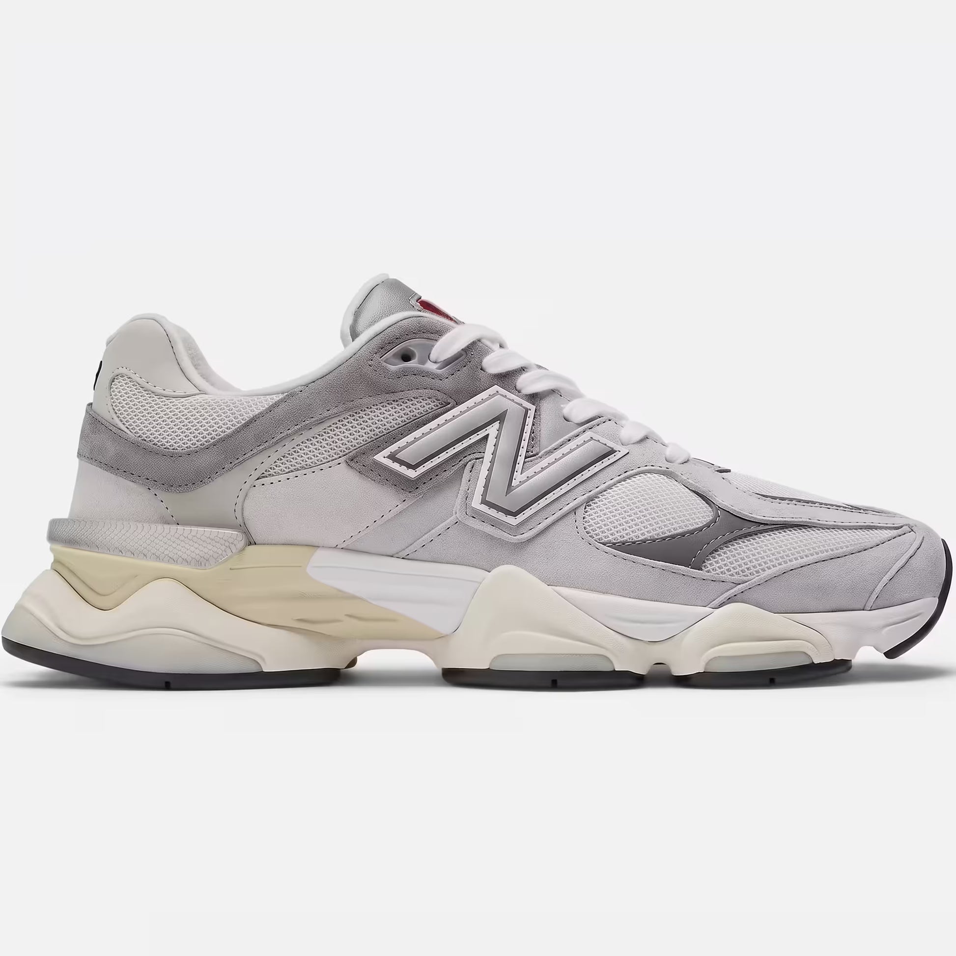 Side profile of New Balance 9060 Rain Cloud Grey (U9060GRY) showing detailed grey pigskin suede overlays, industrial mesh panels, and the signature wavy dual-density ABZORB midsole on a clean concrete surface.