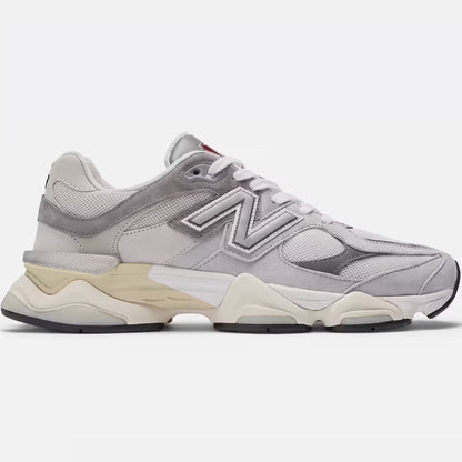 Side profile of New Balance 9060 Rain Cloud Grey (U9060GRY) showing detailed grey pigskin suede overlays, industrial mesh panels, and the signature wavy dual-density ABZORB midsole on a clean concrete surface.