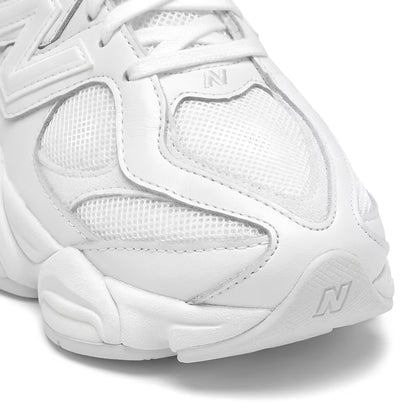 White new balance 9060 sneaker with New Balance logo on a white background closeup shot of the toe box.