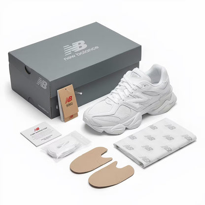 White new balance 9060 sneaker with New Balance packaging, shoe care items, and a card on a white background