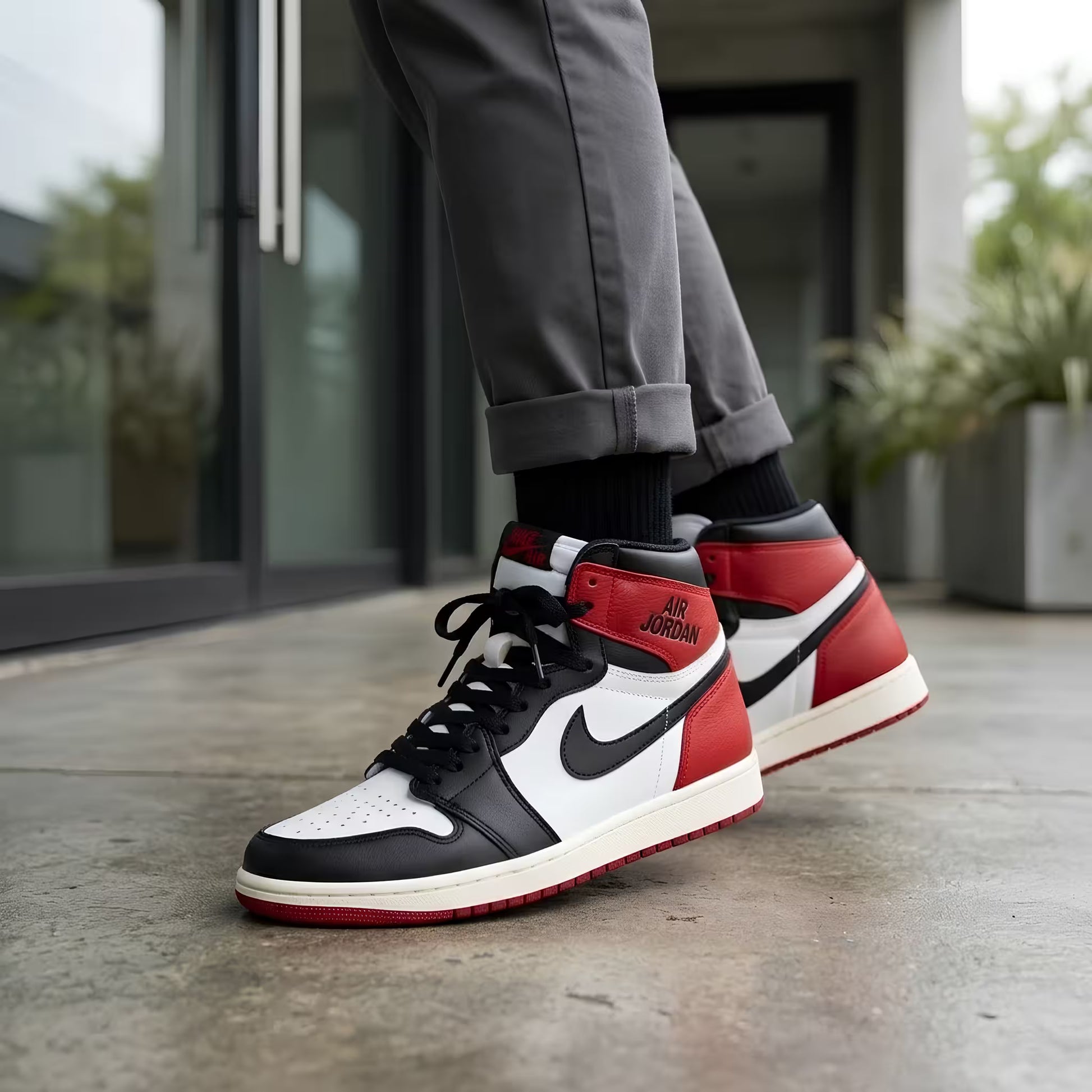 Person wearing black, white, and red high-top shoeswith a blurred background