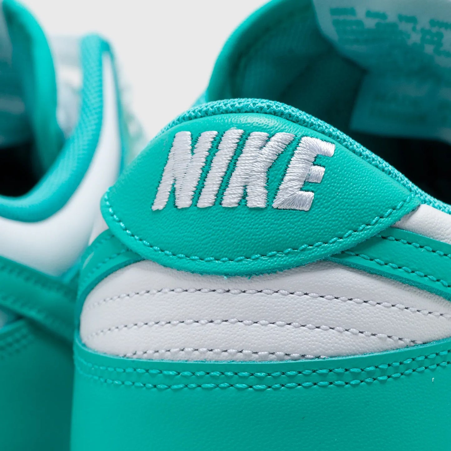 Close-up of a teal and white sneaker with Nike logo