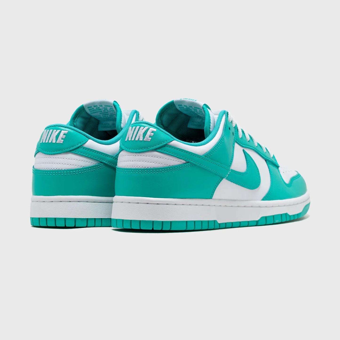 Turquoise and white Nike sneakers on a light gray background