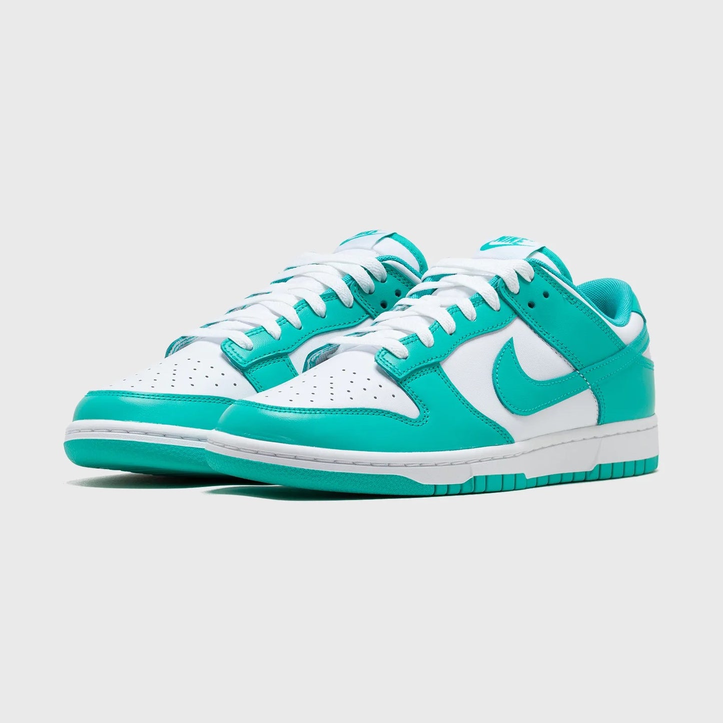 Turquoise and white sneakers with a brand logo on a light gray background