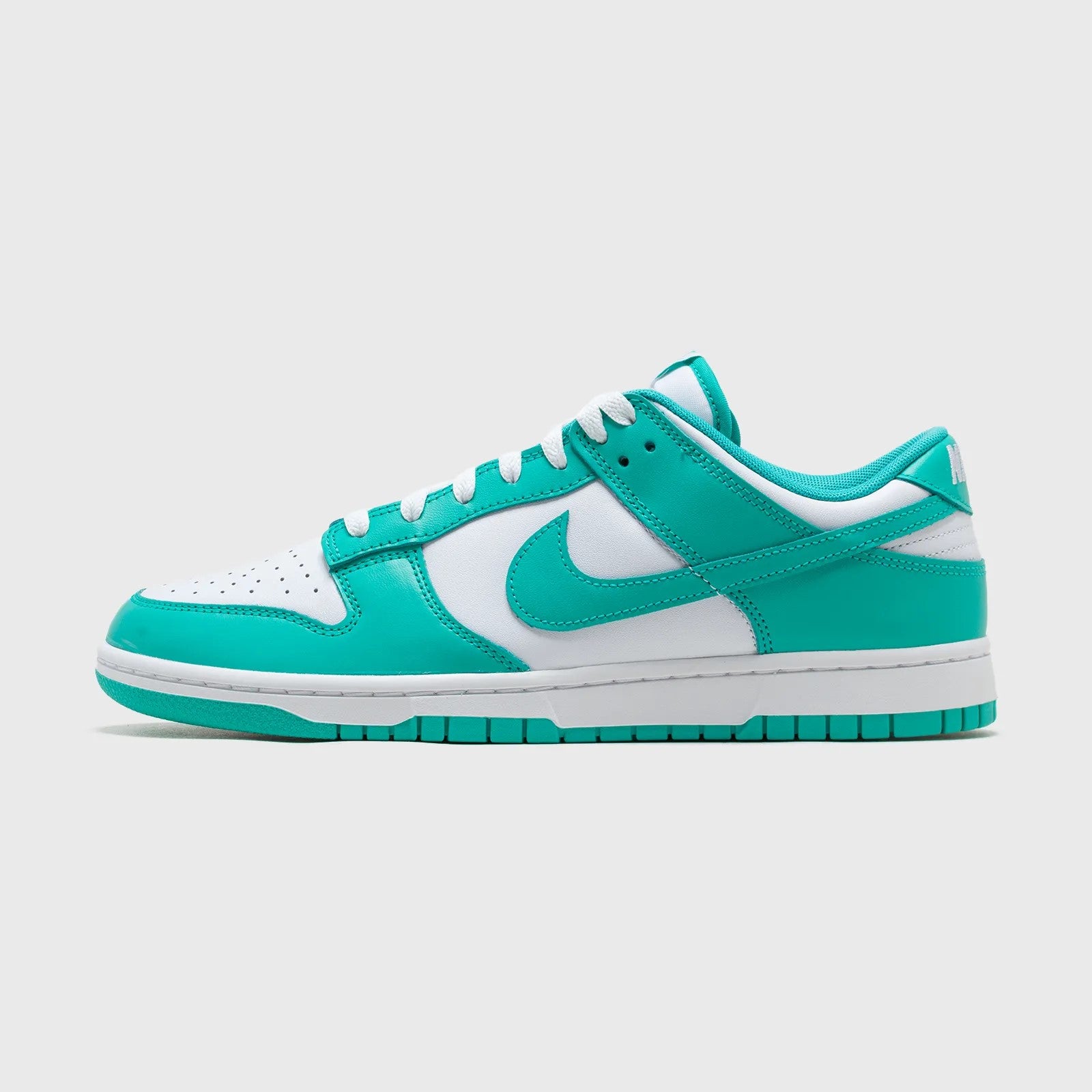 Turquoise and white sneaker with Nike logo on a light gray background