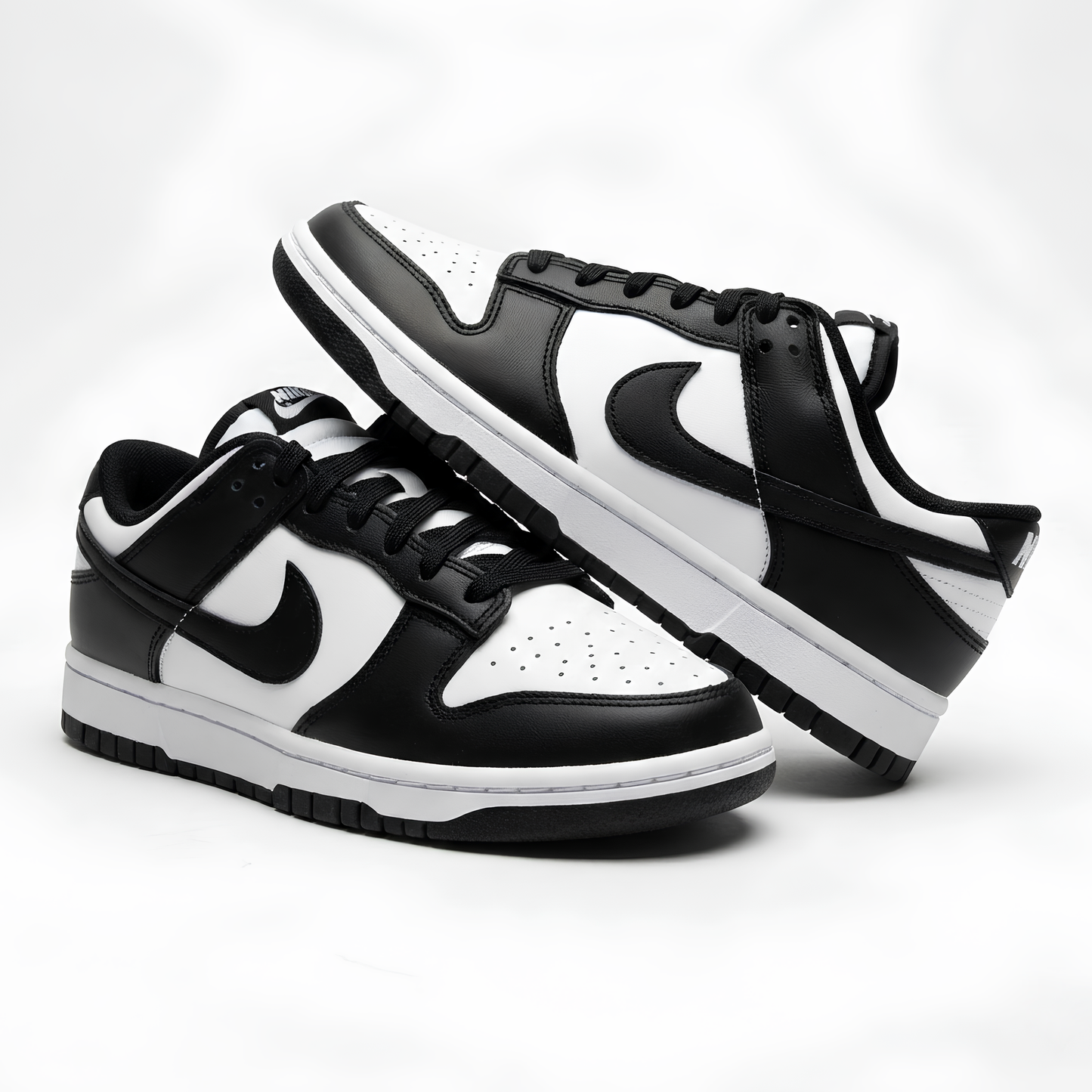 Black and white sneakers with Nike logo on a light gray background