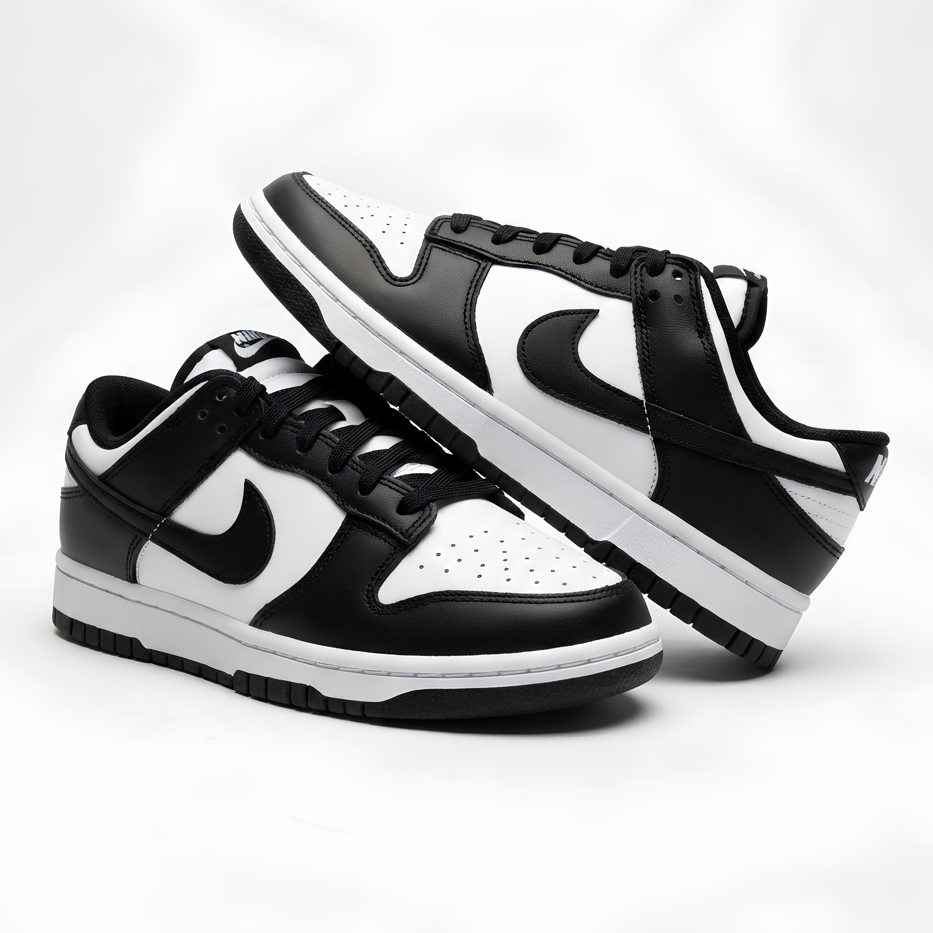 Black and white sneakers with Nike logo on a light gray background