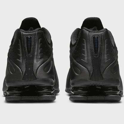 Black athletic shoes with a distinctive sole design on a light gray background