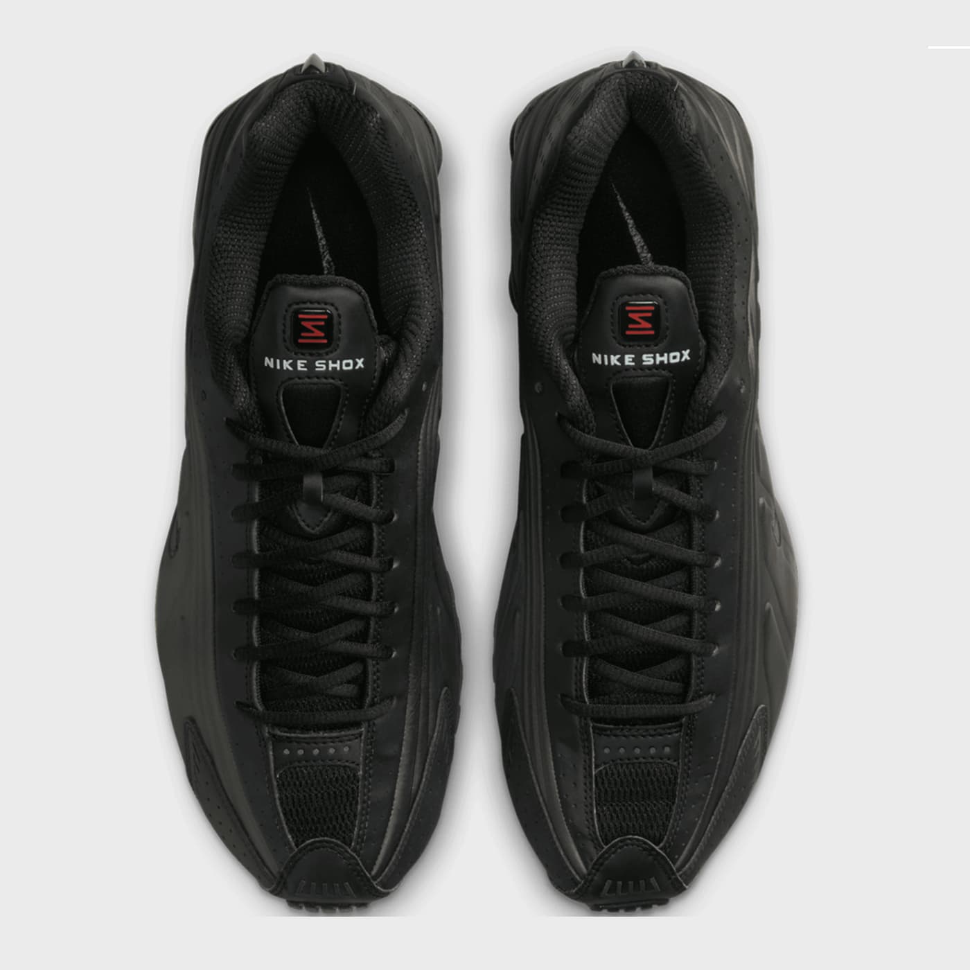 Pair of black Nike Shox sneakers on a light gray background